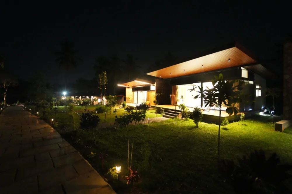 The beautifully illuminated cottages at Alpha Wellness Resort by night